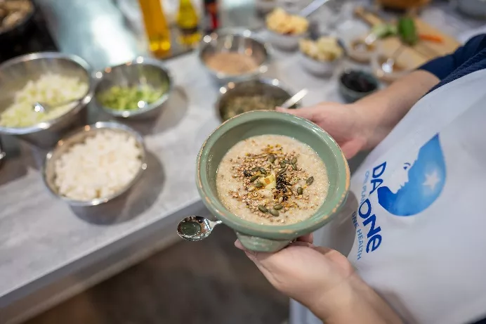 A person holding a bowl of food

Description automatically generated